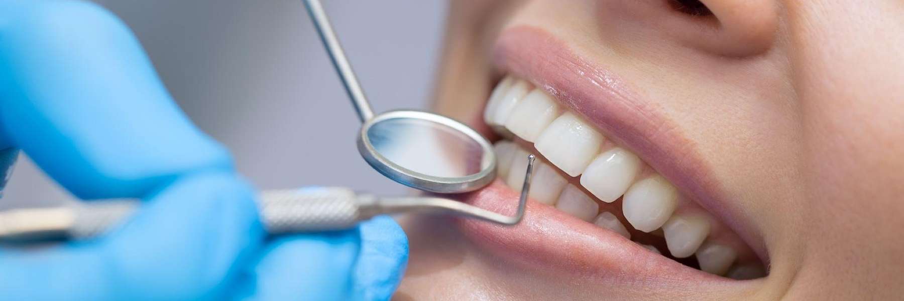 patient smiling with dental tool | dentist near me