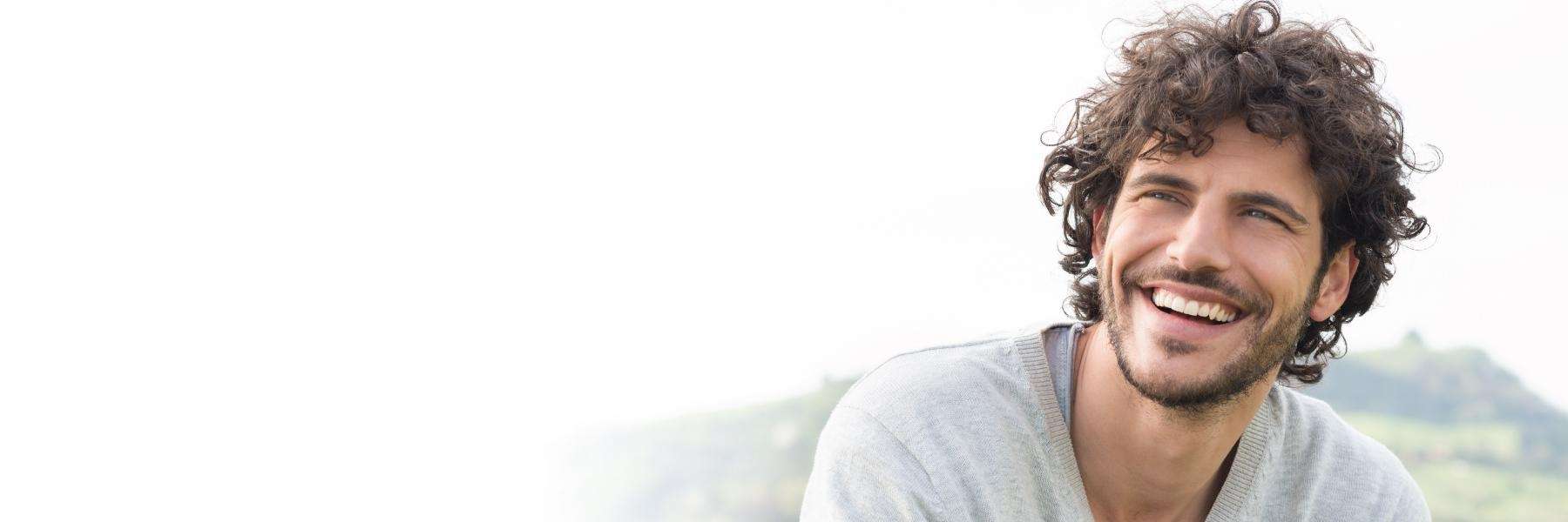 man with curly hair smiling | dentist near me chelsea heights